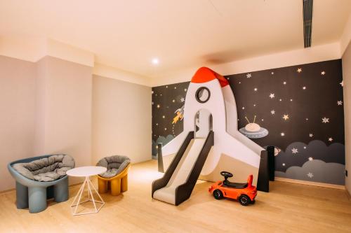 a childs room with a rocket and a slide at Mega Hotel in Chiayi City
