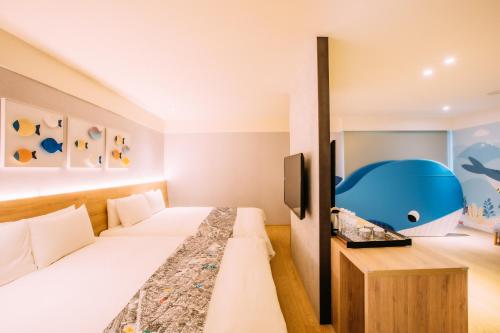 a hotel room with two beds and a blue dolphin room at Mega Hotel in Chiayi City