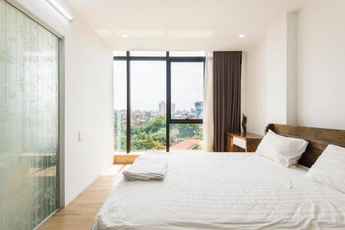 a bedroom with a bed and a large window at 22housing Cau Giay Hotel & Residence in Hanoi