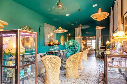 a store with wicker chairs and green walls at Dina Morgabine Saint Gilles in Saint-Gilles les Bains