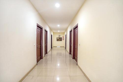 a corridor of a room with doors and tile floors at FabHotel Grand Inn in Jalandhar
