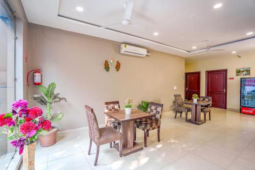 a dining room with a table and chairs and flowers at FabHotel Grand Inn in Jalandhar