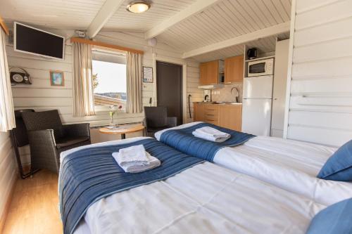 2 camas en una habitación pequeña con cocina en Hafsten Resort, en Sundsandvik