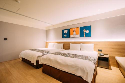 a hotel room with two beds in it at Mega Hotel in Chiayi City