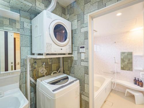 a washer and dryer in a bathroom with a washing machine at Terrace Resort Mihama Chatan in Chatan