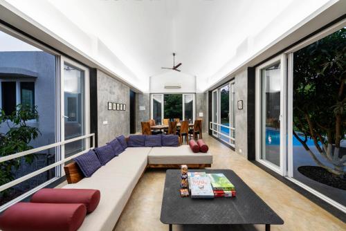 a living room with a couch and a table at SaffronStays Casa Manga, Karjat - pet-friendly pool villa near ND's Film World and Saltt in Karjat
