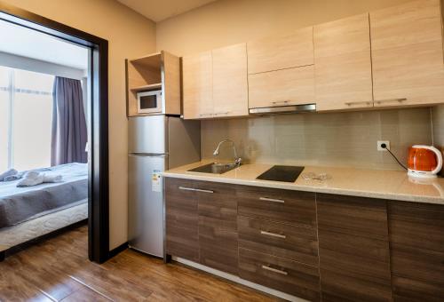 a small kitchen with a sink and a bed at Sani Apart Hotel in Tbilisi City
