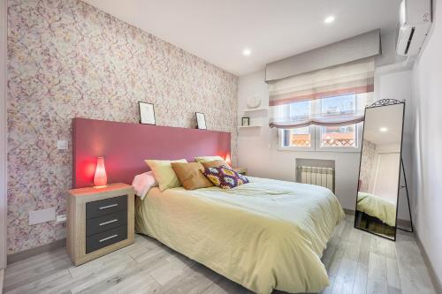 - une chambre avec un grand lit et une tête de lit rouge dans l'établissement Delagua Apartments Atocha I, à Madrid