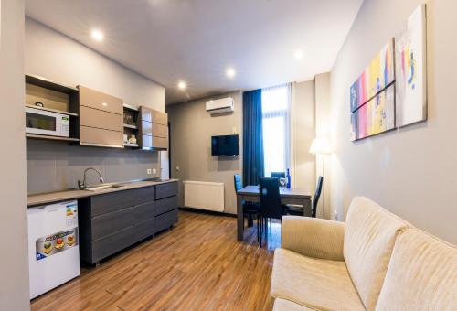 a kitchen and living room with a couch and a table at Sani Apart Hotel in Tbilisi City