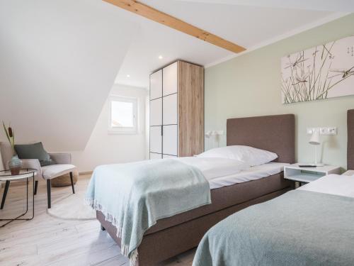 1 dormitorio con 2 camas y 1 silla en Feriendomizil im Luftkurort - Ferienhaus-Sauna-See-Hund en Krakow am See