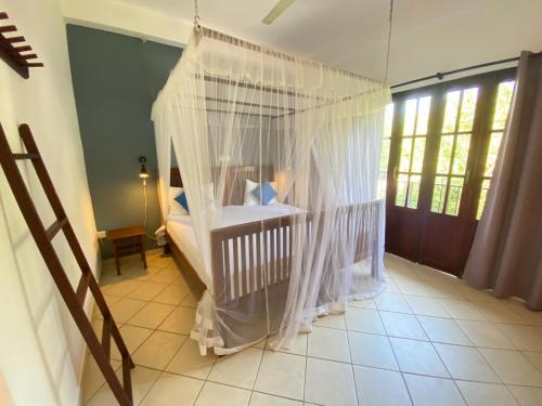 a baby crib with nets in a room at Unawatuna Nor Lanka Hotel in Unawatuna