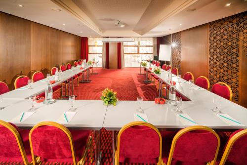 a conference room with a long table and red chairs at Sousse Palace Hotel & Spa in Sousse