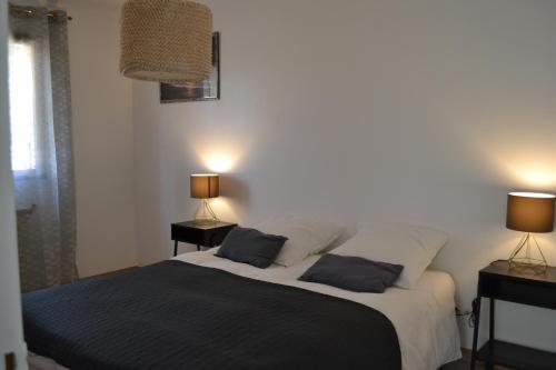 a bedroom with a bed with two lamps on it at Maison au cœur des Cévennes Méridionales in Saint-André-de-Majencoules