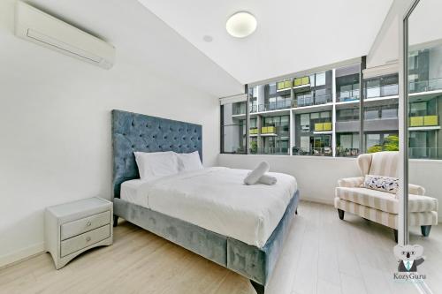 a bedroom with a large bed and a chair at KOZYGURU MASCOT 2 BED APT FREE DOUBLE-PARKING NMA629 in Sydney