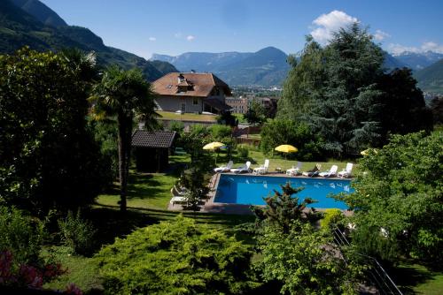 a swimming pool in a yard with a house at Hotel Tannerhof in Merano
