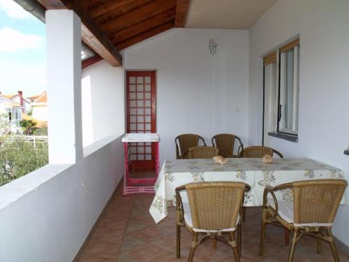 comedor con mesa y sillas en el balcón en Apartments Cerin, en Fažana
