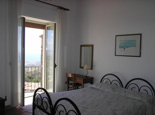 a bedroom with a bed and a sliding glass door at Casa Ferrari in Gerace