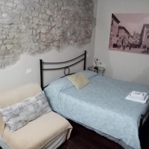 a small bedroom with a bed and a chair at B&B La Cupella in Monterotondo