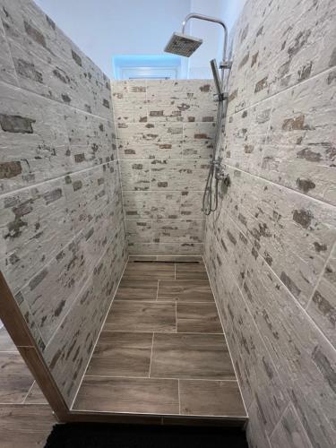 a bathroom with a shower with a stone wall at Cottbuser City Ferienwohnung in Cottbus