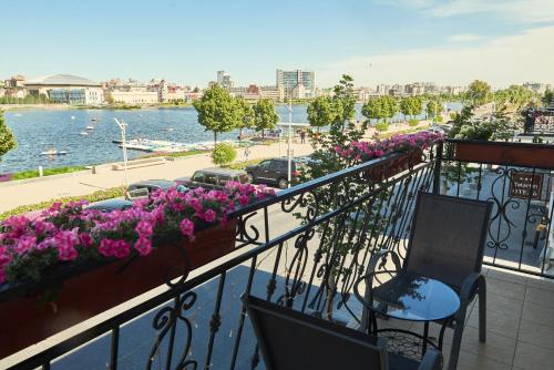 balkon z kwiatami i widokiem na wodę w obiekcie TatarInn Hotel w Kazaniu