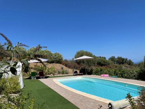 - une piscine dans une cour avec des chaises et des parasols dans l'établissement Le Clos des Milans, à Rapale