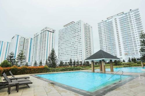 ein Schwimmbad vor einigen hohen Gebäuden in der Unterkunft A2J Executive Studio Suite near Skyranch & Malls Tagaytay in Tagaytay