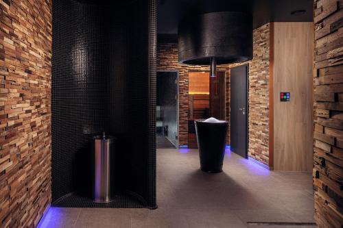 a hallway with a trash can and a brick wall at Grund Resort Golf and Ski in Mladé Buky