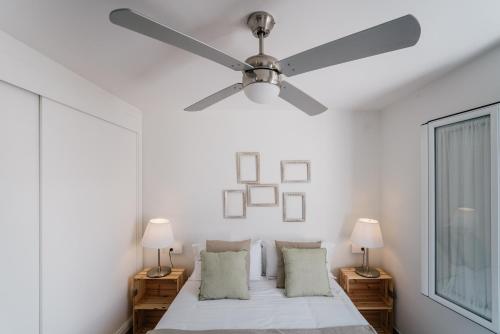 a white bedroom with a ceiling fan and a bed at Eva Recommends Capilla de la Jura en Jerez in Jerez de la Frontera
