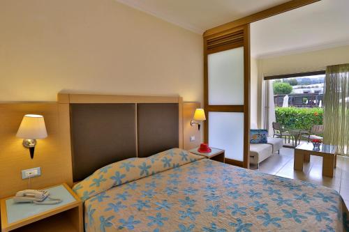 a hotel room with a bed and a balcony at Sol Cosmopolitan Rhodes in Ixia