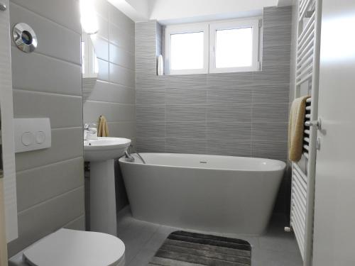 a bathroom with a tub and a toilet and a sink at TRUST Apartaments 2 in Braşov