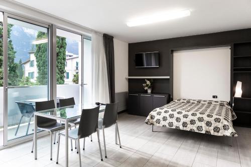 リーヴァ・デル・ガルダにあるApartments Garda Lakeのベッドルーム1室(ベッド1台、テーブル、椅子付)