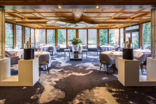 a dining room with tables and chairs and windows at Restaurant Hôtel L'Arnsbourg in Baerenthal