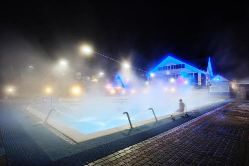 a large pool of water in a city at night at Aqua Vita Thermal SPA in Mostovskoy