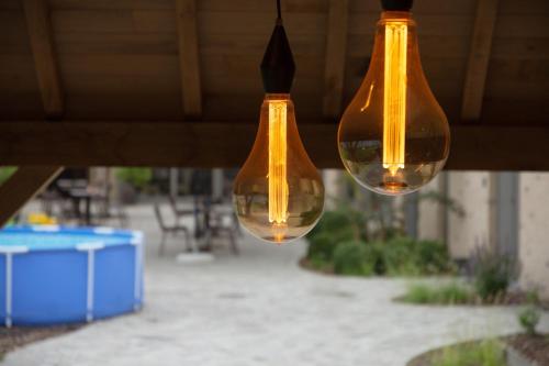 two glass lights hanging from a ceiling with a patio at Oud Gemeentehuis in Poelkapelle