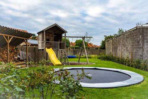 a playground with a trampoline in a yard at Oud Gemeentehuis in Poelkapelle