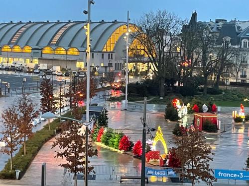 a large building with christmas trees in a city at Hôtel Porte Mars Reims Gare Centre Arena in Reims