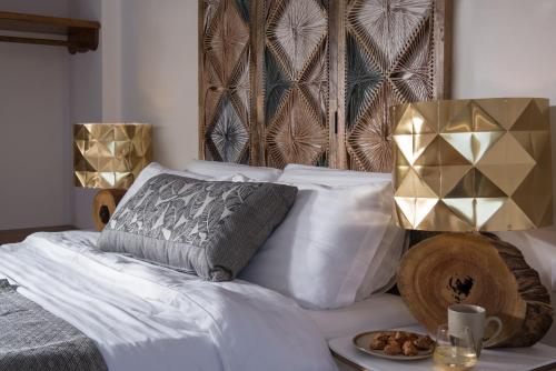 a bedroom with a bed with a plate of food on it at White & Co Exclusive Island Villas in Pirgos