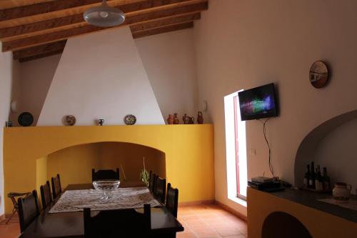 a dining room with a table and a tv at Casa da Estalagem - Turismo Rural in Ervidel