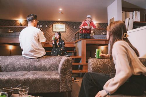 un grupo de personas sentadas en una habitación con una mujer en GRAND BASE Hakata Bay, en Fukuoka