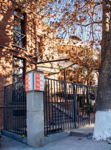 a fence in front of a building with a tree at Sani Apart Hotel in Tbilisi City