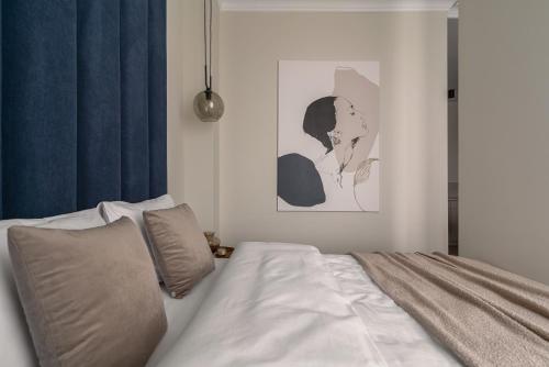a bedroom with a bed and a picture of a woman at APARTIO ROOMS Katowice in Katowice