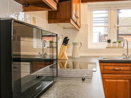 a kitchen with a glass refrigerator and a sink at The Little Beehive in Worcester