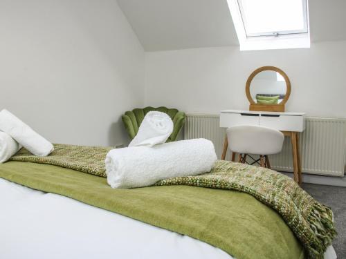 a bedroom with a bed with two towels on it at The Little Beehive in Worcester