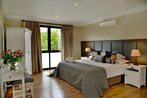 a bedroom with a large bed and a large window at Thanda Manzi Country Hotel in Centurion