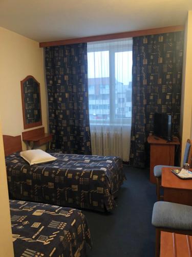 a hotel room with two beds and a window at HOTEL MUNTENIA in Campina