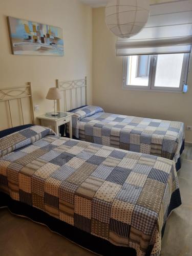 due letti in una stanza con due finestre di Vistamar Estepona a Estepona