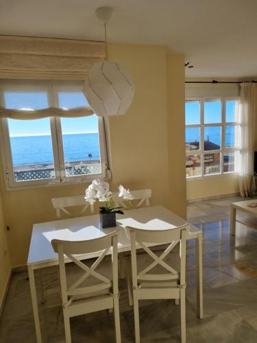 una sala da pranzo con tavolo e sedie e l'oceano di Vistamar Estepona a Estepona