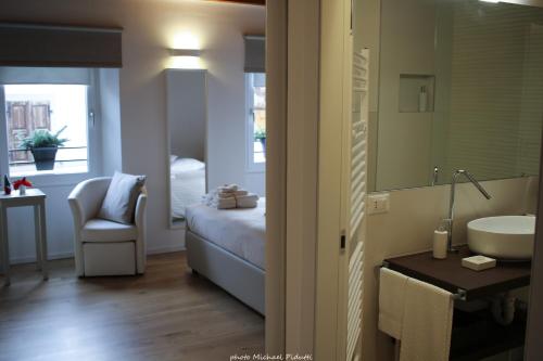 a bathroom with a bed and a sink and a mirror at Affittacamere CASA DOLCE CASA SAN DANIELE in San Daniele del Friuli