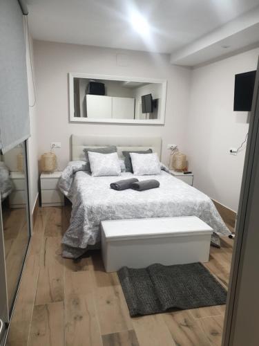 1 dormitorio con cama blanca y espejo en Villa Minerva, en Arriate