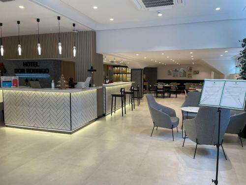 a restaurant with a bar with chairs and tables at Hotel Don Rodrigo in Palencia